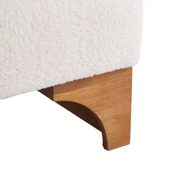 Sillón Homy Casa con respaldo enrollado y base de madera maciza, tapicería de bouclé