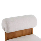 Sillón Homy Casa con respaldo enrollado y base de madera maciza, tapicería de bouclé