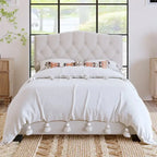 Base de cama tapizada con plataforma, cabecero curvo tipo silla de montar y detalles de rombos capitoné